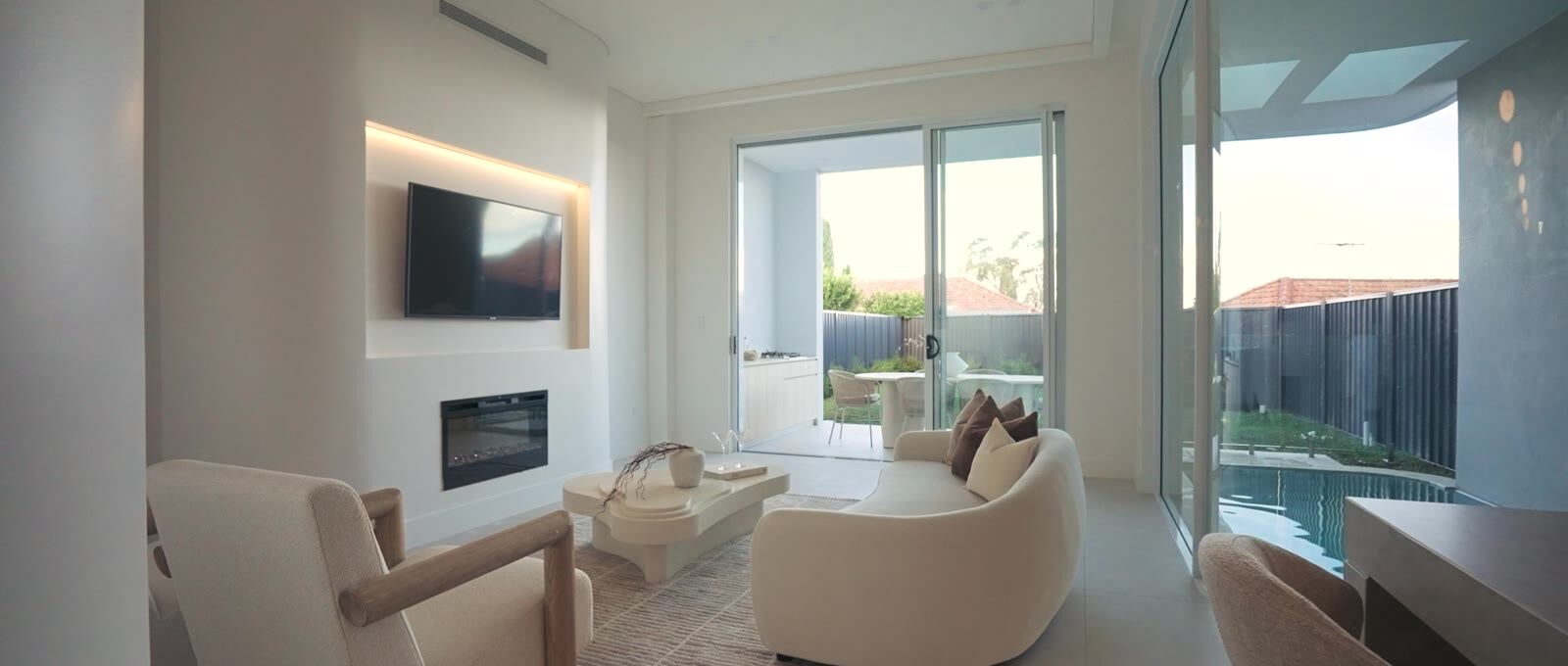 Living room with fireplace, curved seating and garden outlook